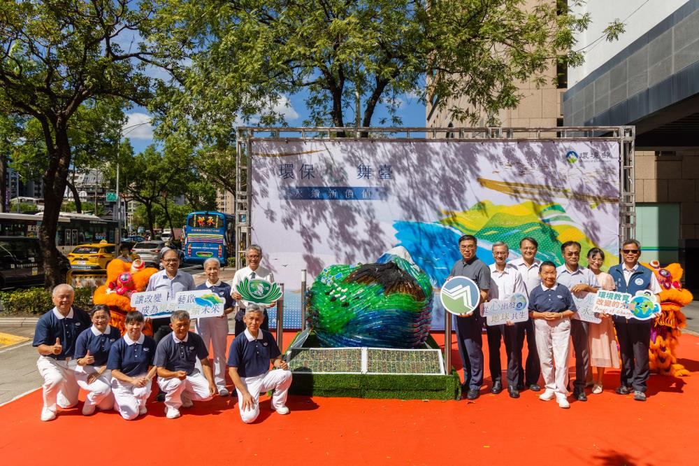 綠能愛地球裝置藝術展出現場，以回收保特瓶創作的大型地球造型藝術品，周圍有民眾與工作人員合影